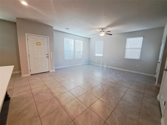 an empty room with windows and fan