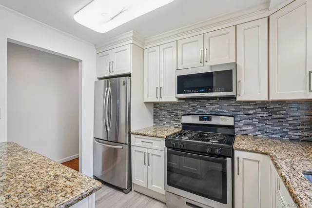 a kitchen with stainless steel appliances granite countertop a refrigerator stove and microwave