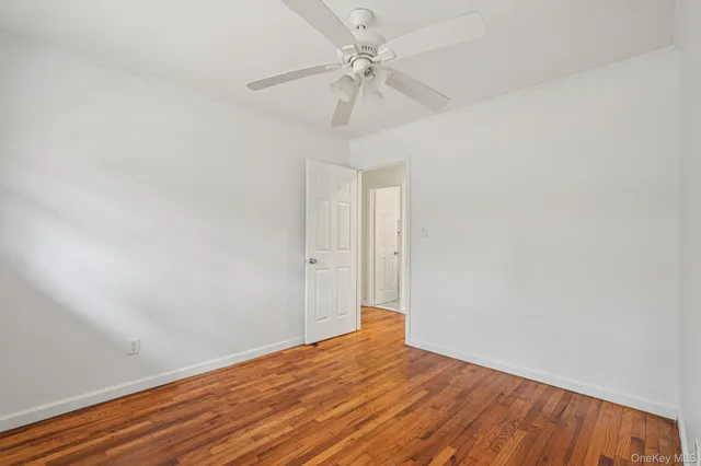 an empty room with a window and a ceiling fan