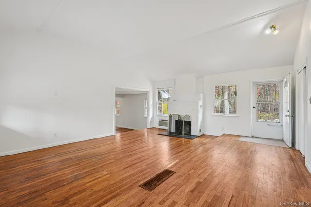 a view of empty room with wooden floor and fireplace
