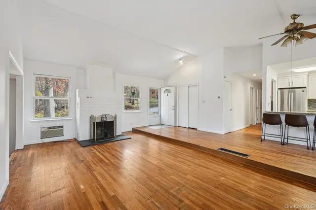 a view of empty room with wooden floor and fireplace