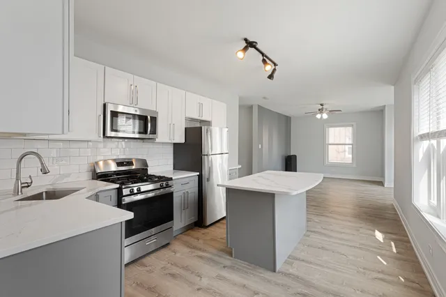 a kitchen with kitchen island a sink appliances and cabinets