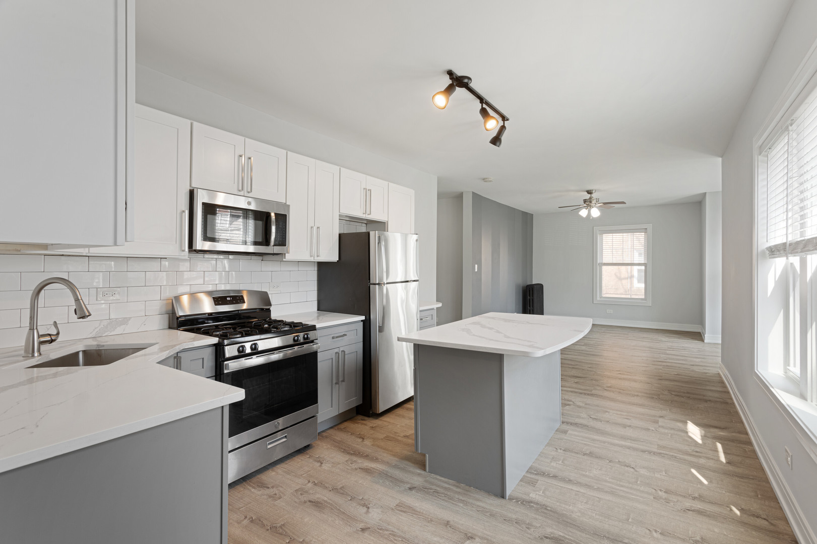 6942 North Wolcott Avenue, Unit 1 Chicago, IL 60626 - Photo 3 of 15 a kitchen with kitchen island a sink appliances and cabinets