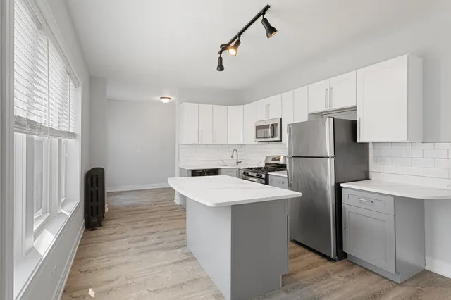 a kitchen with refrigerator cabinets and wooden floor