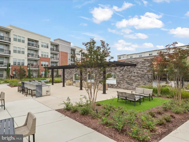 a living room with stainless steel appliances furniture a flat screen tv and a large window