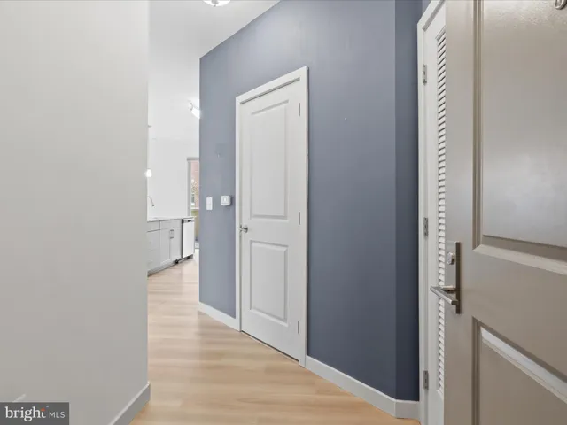 a kitchen with stainless steel appliances granite countertop a stove a sink dishwasher a refrigerator white cabinets with wooden floor