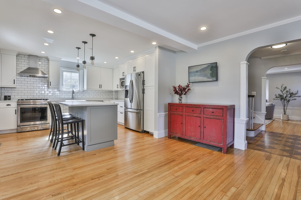 10 Lawndale Road Milton, MA 02186 - Photo 3 of 42 a kitchen with stainless steel appliances kitchen island granite countertop wooden floors and a view of living room