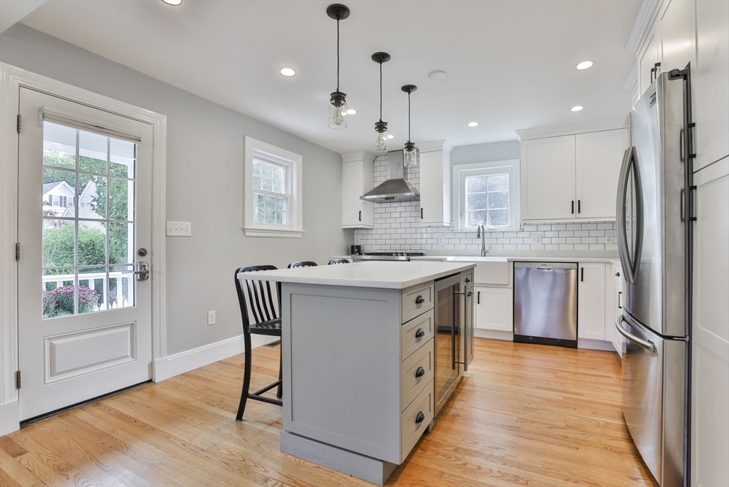 10 Lawndale Road Milton, MA 02186 - Photo 4 of 42 a kitchen with stainless steel appliances granite countertop a stove a sink a refrigerator and a dining table with wooden floor