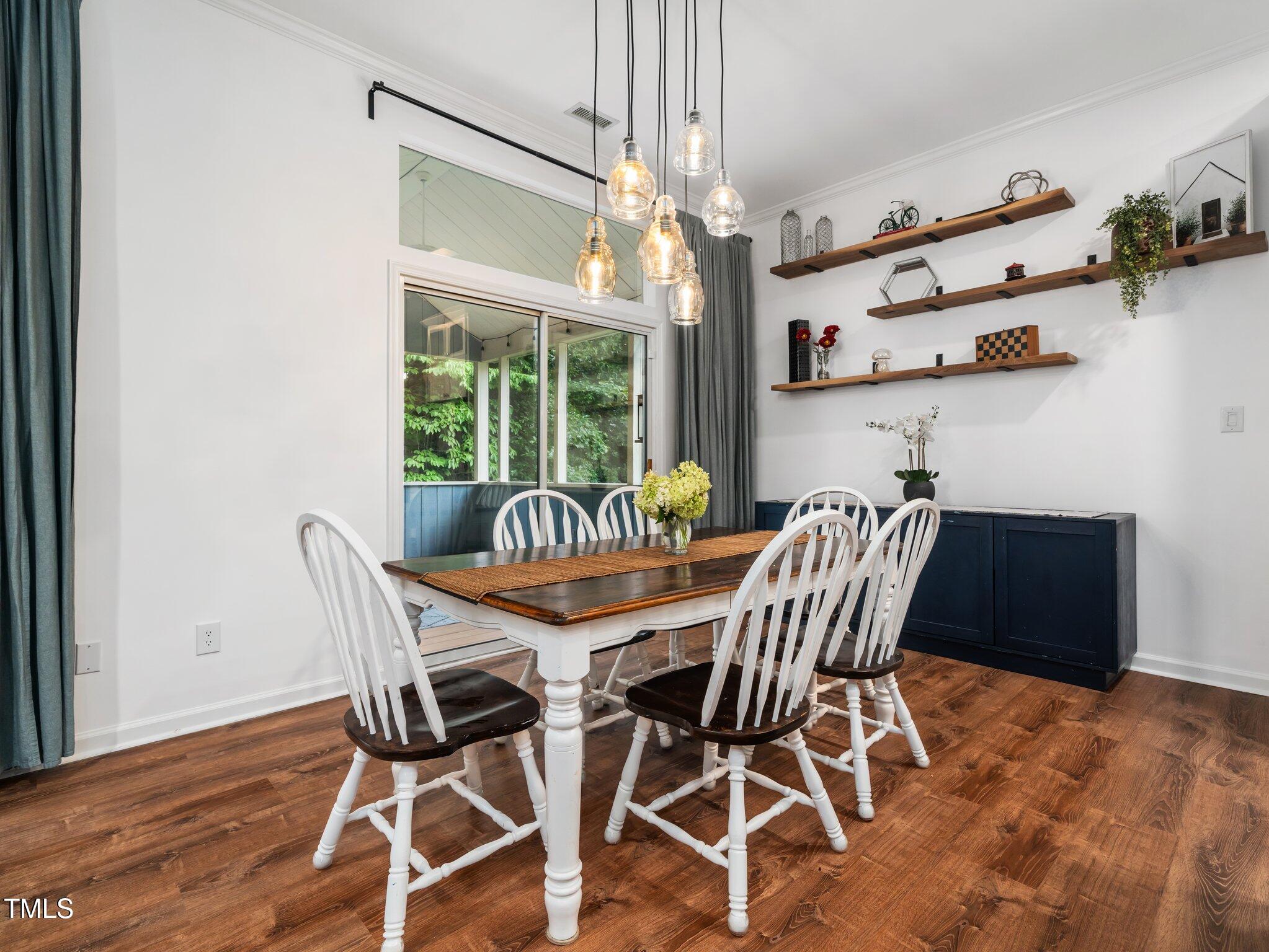 3400 Appling Way Durham, NC 27703 - Photo 9 of 30 a view of a dining room with furniture a chandelier and wooden floor