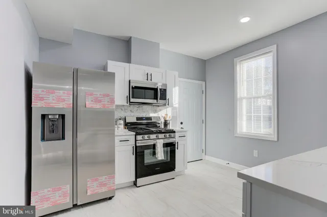 a kitchen with stainless steel appliances a stove a sink and a refrigerator