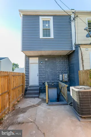 a backyard of a house with barbeque oven and parked