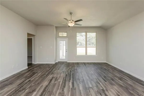 an empty room with a window and a fan