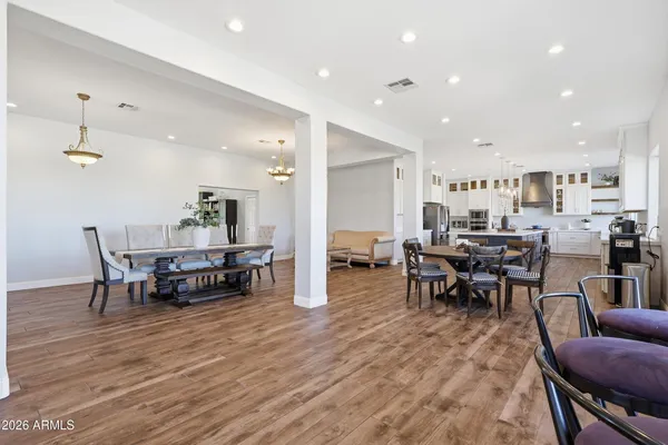 a living room with furniture kitchen view and a chandelier