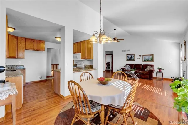 a dining room with furniture potted plants and wooden floor