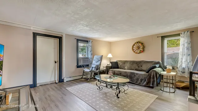 a living room with furniture a wooden floor and a flat screen tv