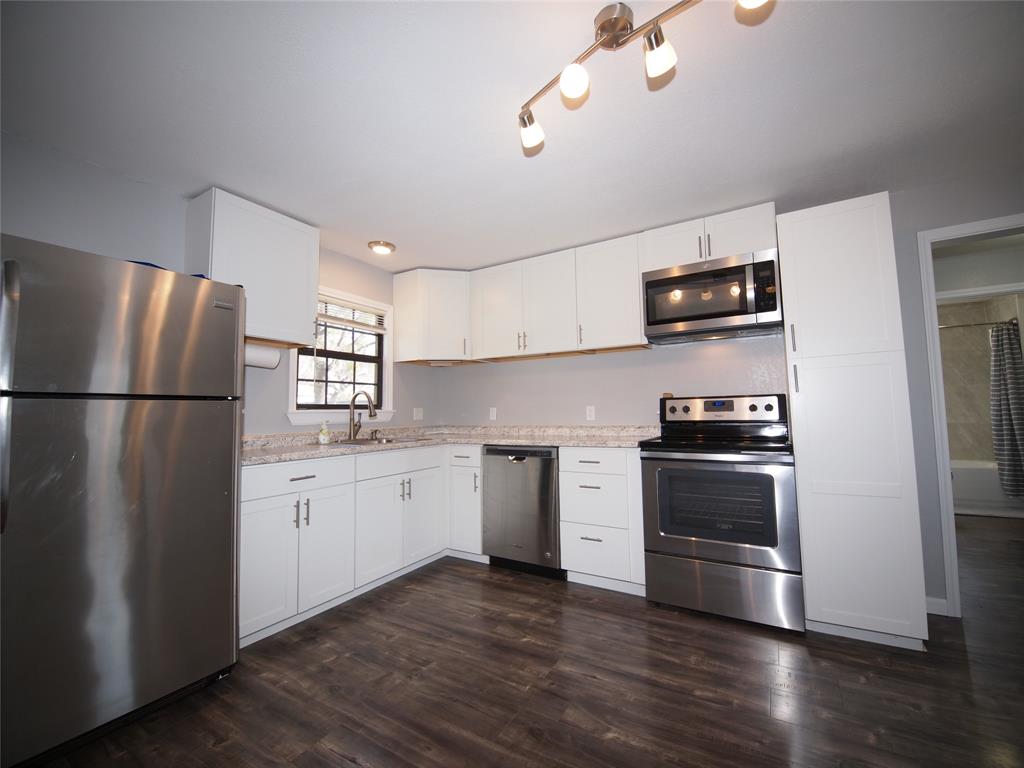 1327 Old Jacksboro Road Graham, TX 76450 - Photo 2 of 33 a kitchen with stainless steel appliances a refrigerator and a stove top oven