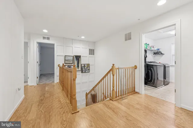 a view of a hallway with wooden floor and staircase