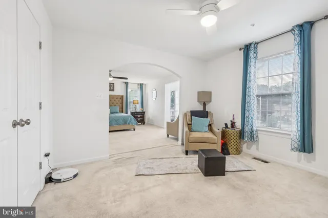 a bedroom with a bed and large windows