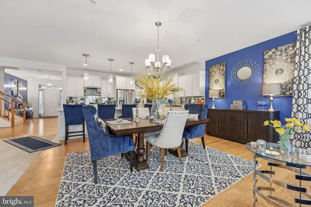 a living room with dining table and a chandelier