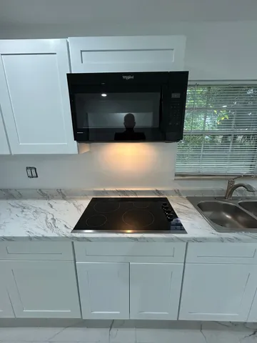 a kitchen with a sink a microwave and cabinets