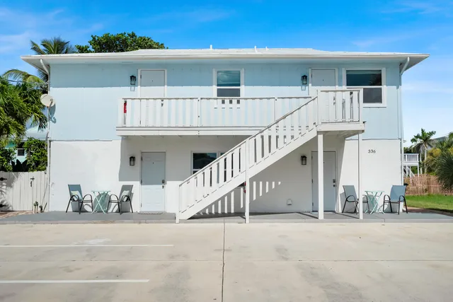 front view of a house with a white wall and potted plants