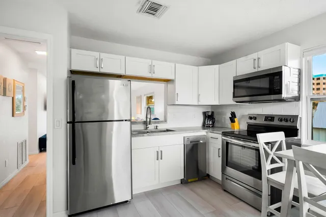 a kitchen with cabinets stainless steel appliances and a counter space