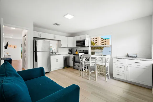 a kitchen with white cabinets and stainless steel appliances