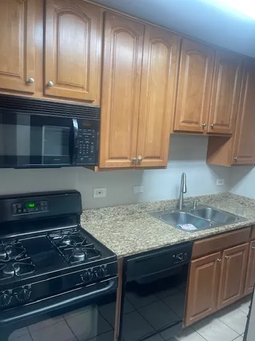 a kitchen with granite countertop stainless steel appliances stove top oven and cabinets