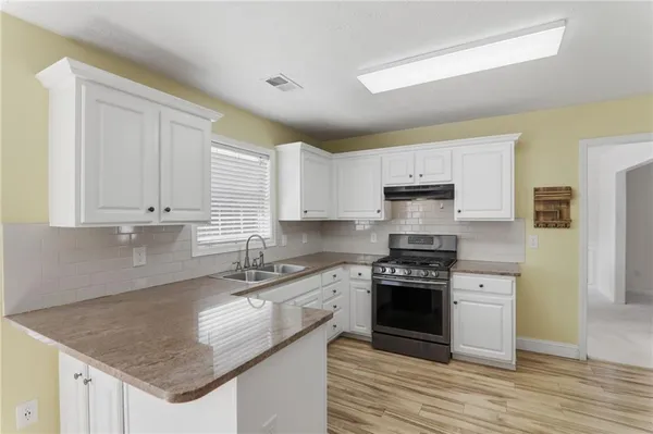 a kitchen with stainless steel appliances granite countertop a stove a sink and a refrigerator