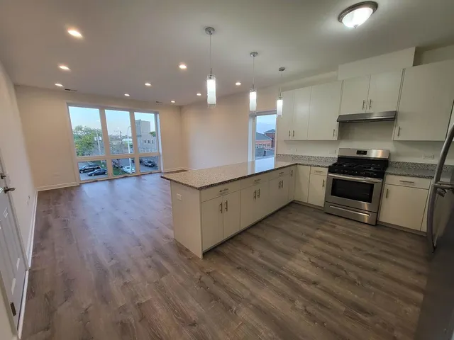 a kitchen with stainless steel appliances granite countertop a stove a sink and a refrigerator