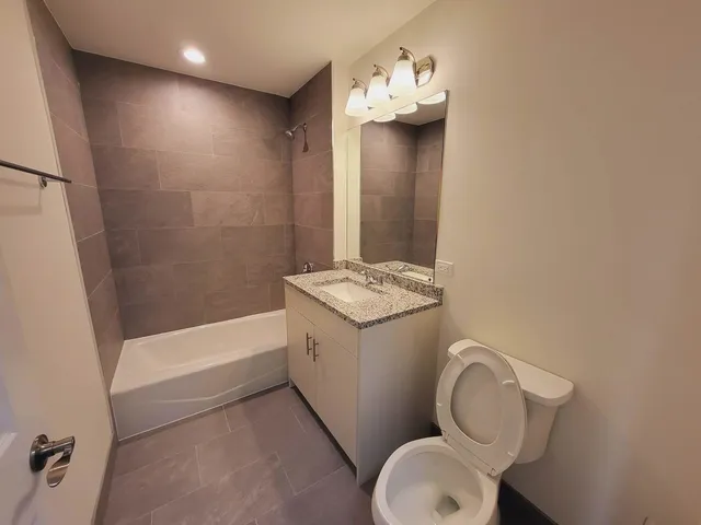 a bathroom with a granite countertop sink toilet and shower