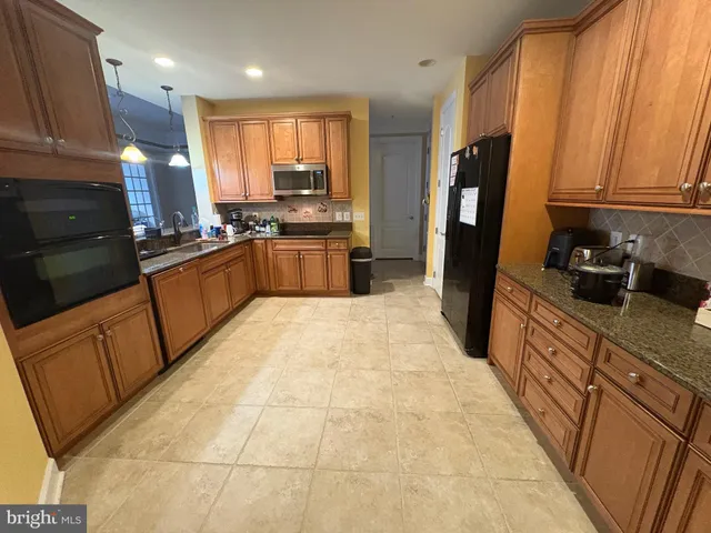 a large kitchen with a large counter top space appliances and cabinets