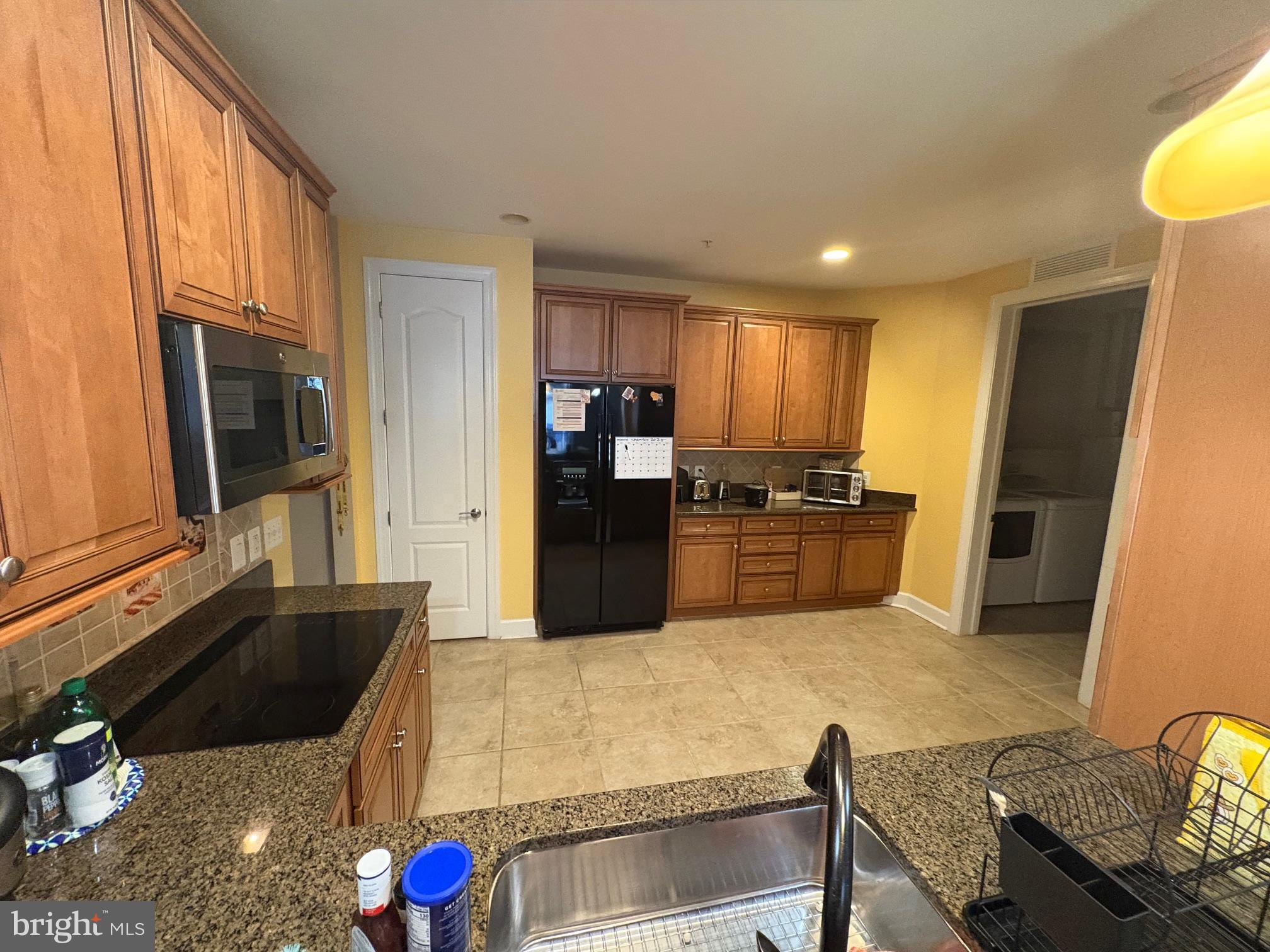 1915 Towne Centre Boulevard, Unit 309 Annapolis, MD 21401 - Photo 4 of 25 a kitchen with granite countertop a sink stainless steel appliances a counter top space and cabinets