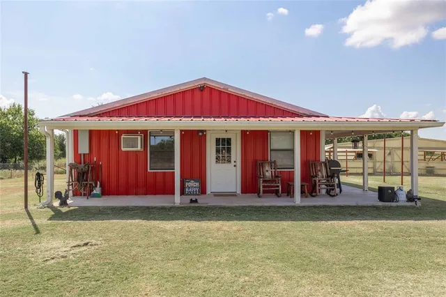 a view of a house with large windows and plants