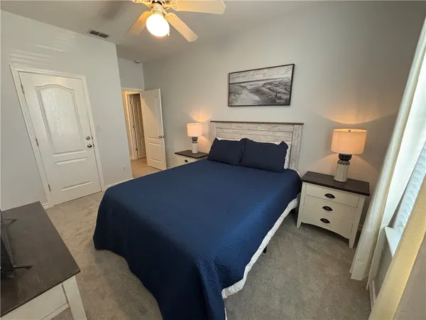 a spacious bedroom with a bed and a chandelier
