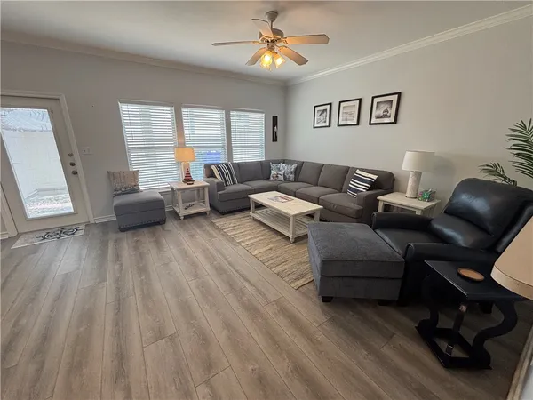 a living room with furniture and a wooden floor