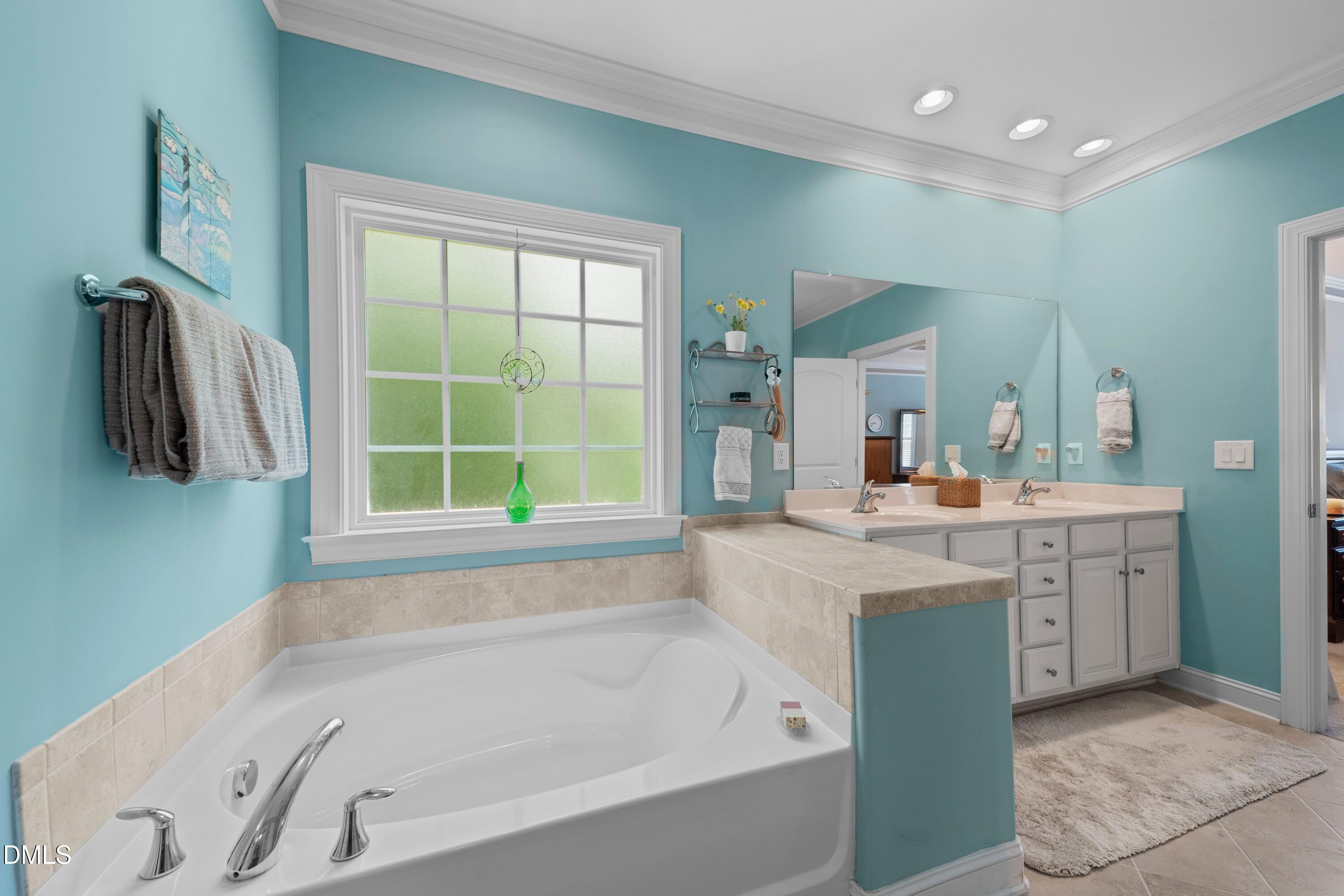 671 Whisper Ridge Drive Graham, NC 27253 - Photo 17 of 41 a bathroom with a tub sink and a window