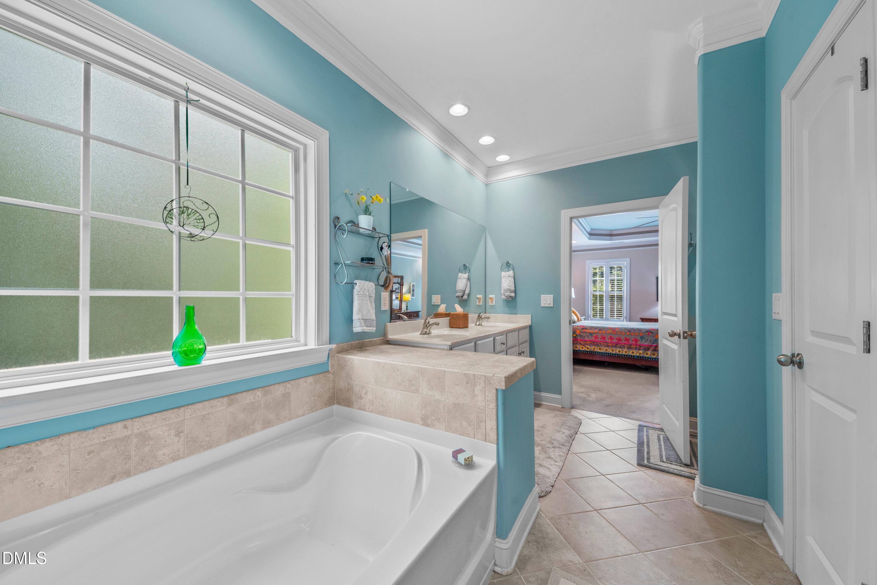 671 Whisper Ridge Drive Graham, NC 27253 - Photo 18 of 41 a en suite bathroom with a tub sink and mirror