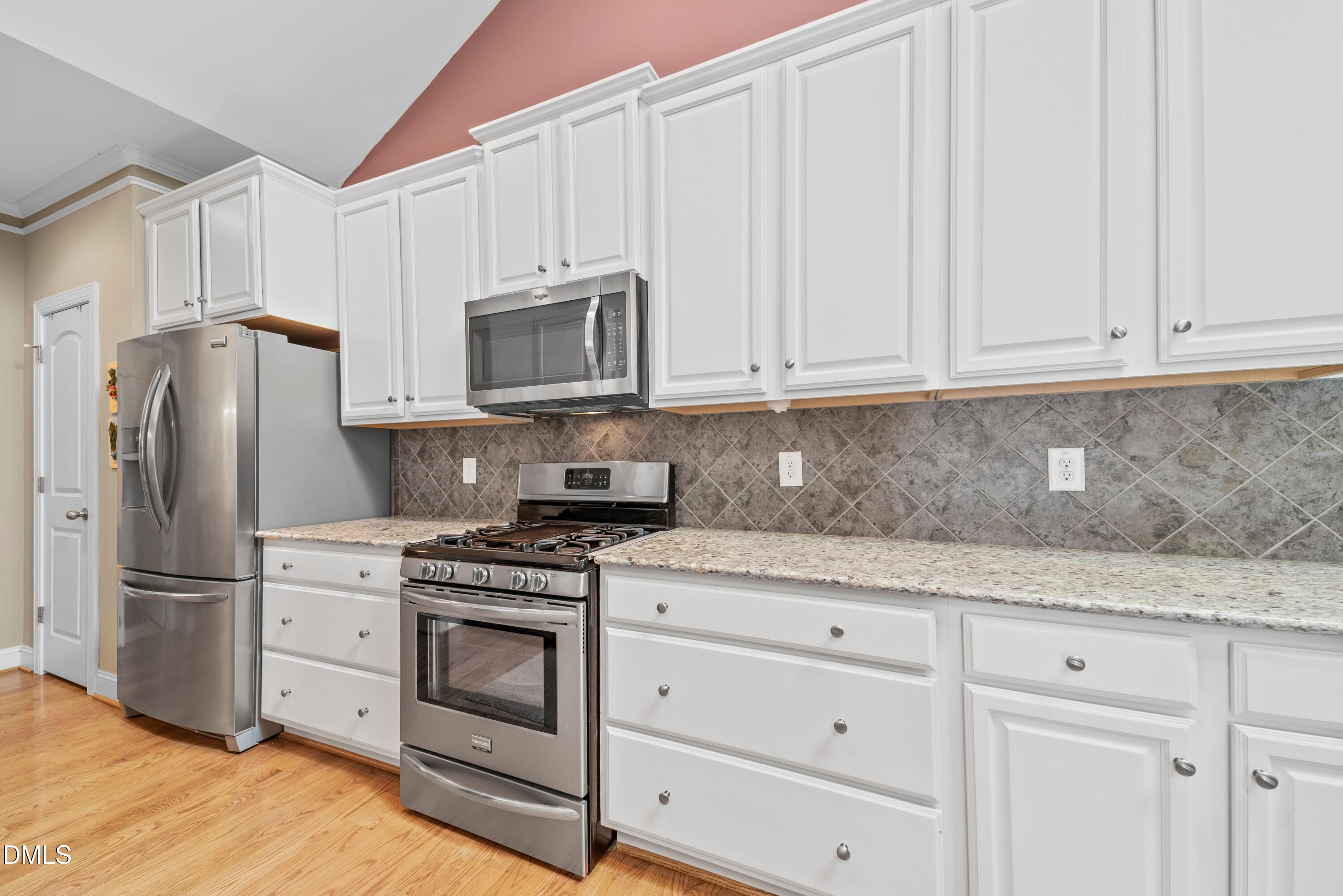 671 Whisper Ridge Drive Graham, NC 27253 - Photo 6 of 41 a kitchen with granite countertop white cabinets and stainless steel appliances