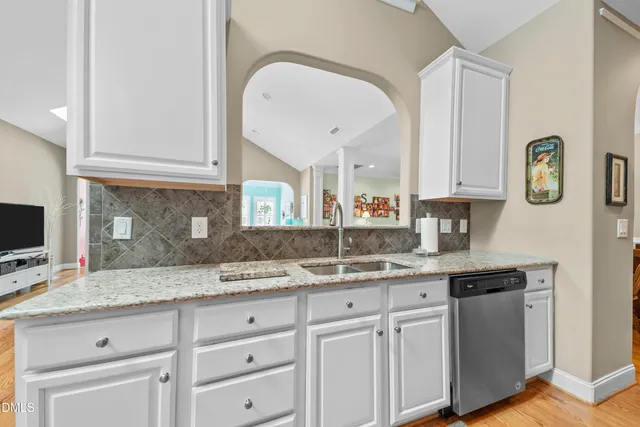 a kitchen with granite countertop a sink stainless steel appliances and cabinets