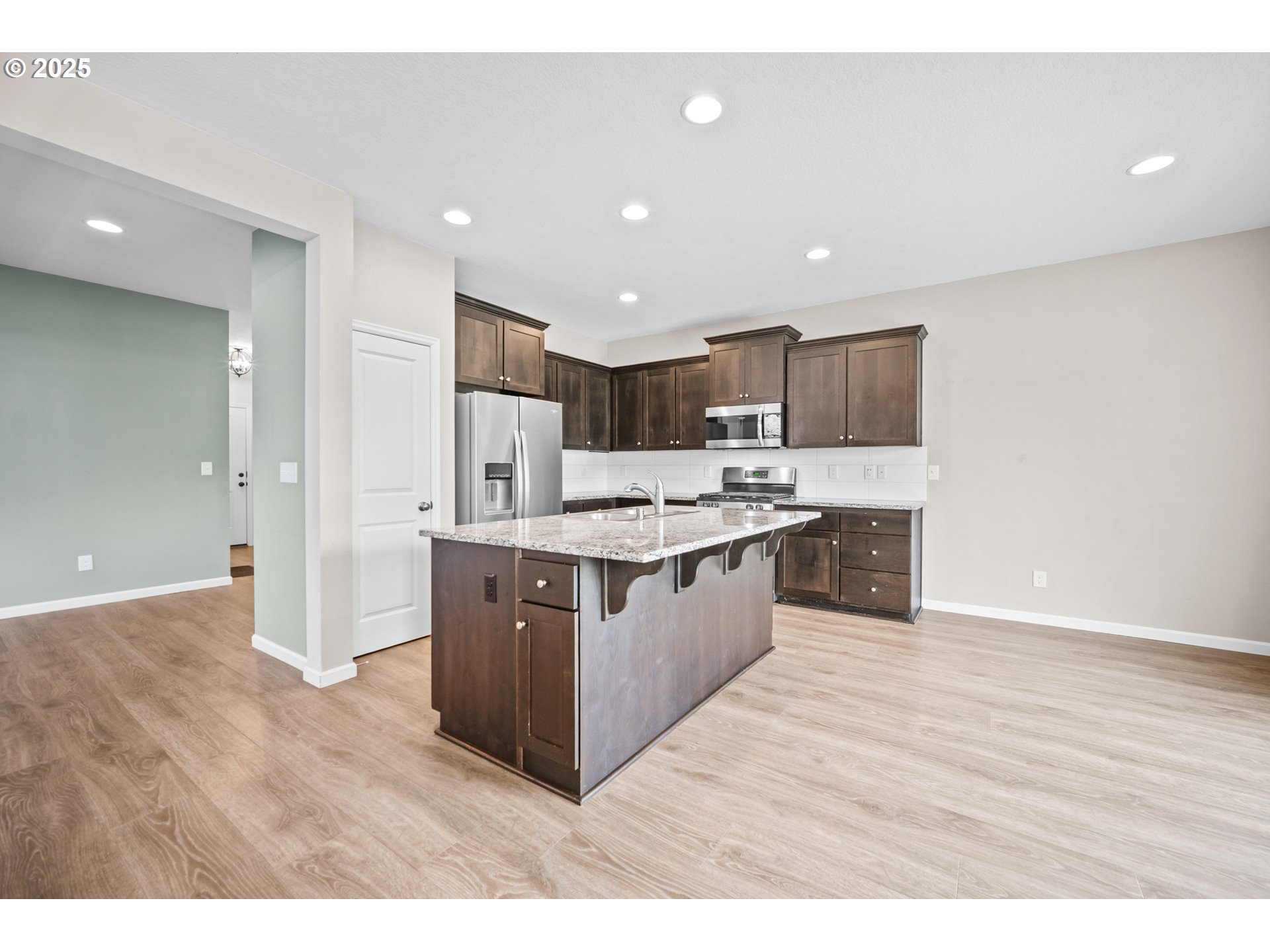 2777 South Red Tail Loop Ridgefield, WA 98642 - Photo 8 of 37 a large kitchen with stainless steel appliances a large counter top and a wooden floors