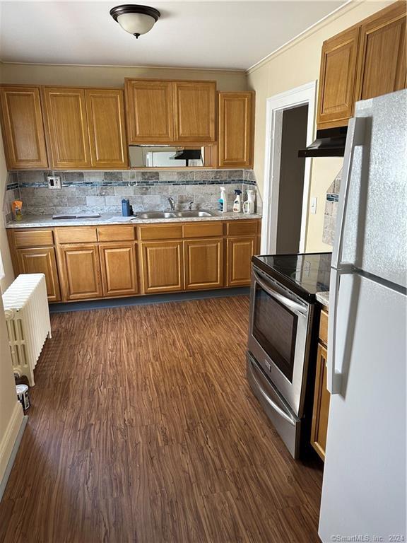 a kitchen with wooden floors and refrigerator