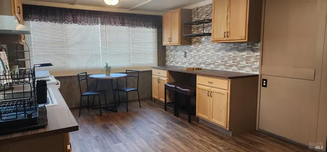 a kitchen with granite countertop a sink cabinets and wooden floor