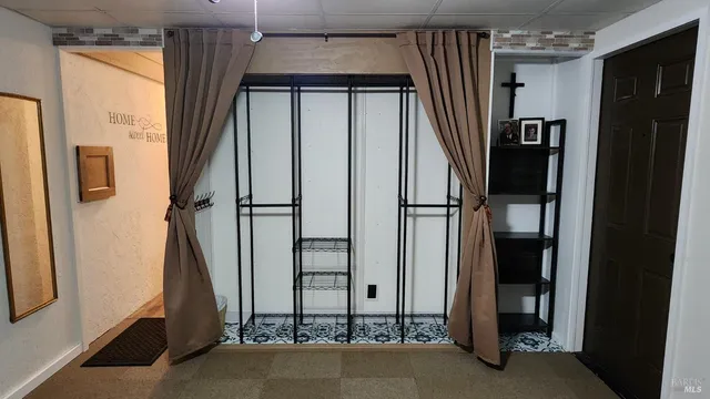 an empty room with staircase mirror and window