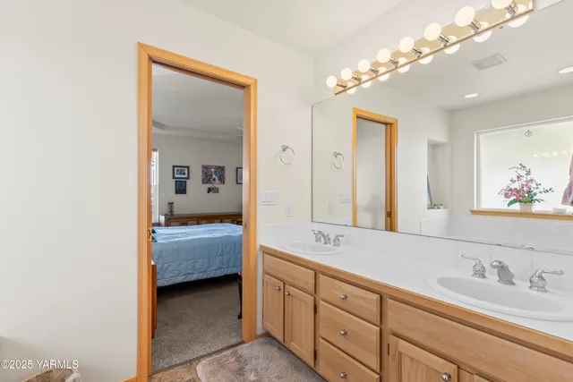 a en suite bathroom with a double vanity sink a mirror and shower