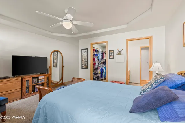 a bedroom with bed and a flat tv screen on dresser