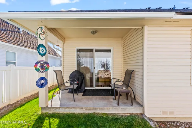 a view of a two chairs in the back yard of the house