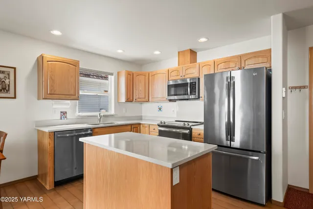 a kitchen with stainless steel appliances granite countertop a refrigerator a sink a stove a microwave and island