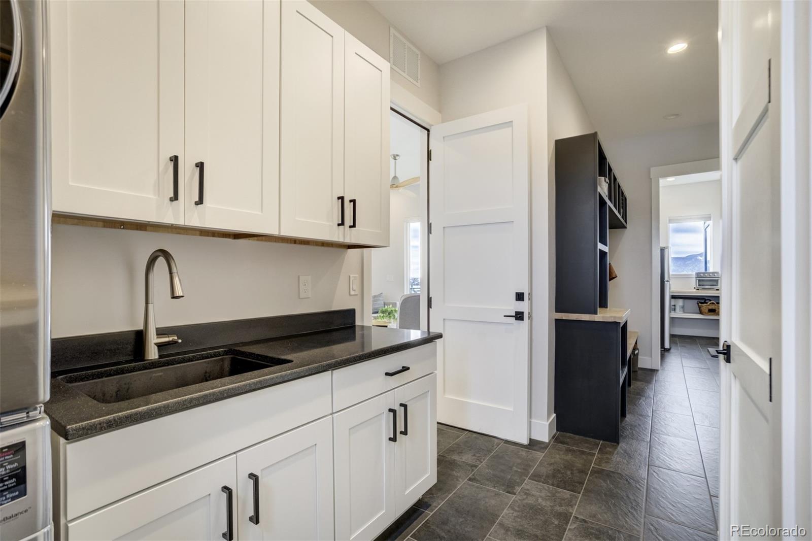 1287 Kelso Place Colorado Springs, CO 80921 - Photo 16 of 50 a kitchen with granite countertop white cabinets and refrigerator
