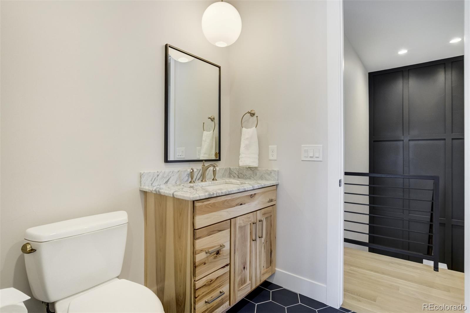 1287 Kelso Place Colorado Springs, CO 80921 - Photo 21 of 50 a bathroom with a toilet a sink and mirror